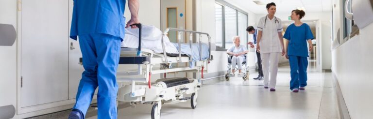 Doctors pushing gurney in hospital corridor