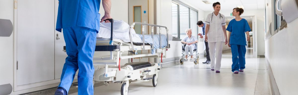 Doctors pushing gurney in hospital corridor