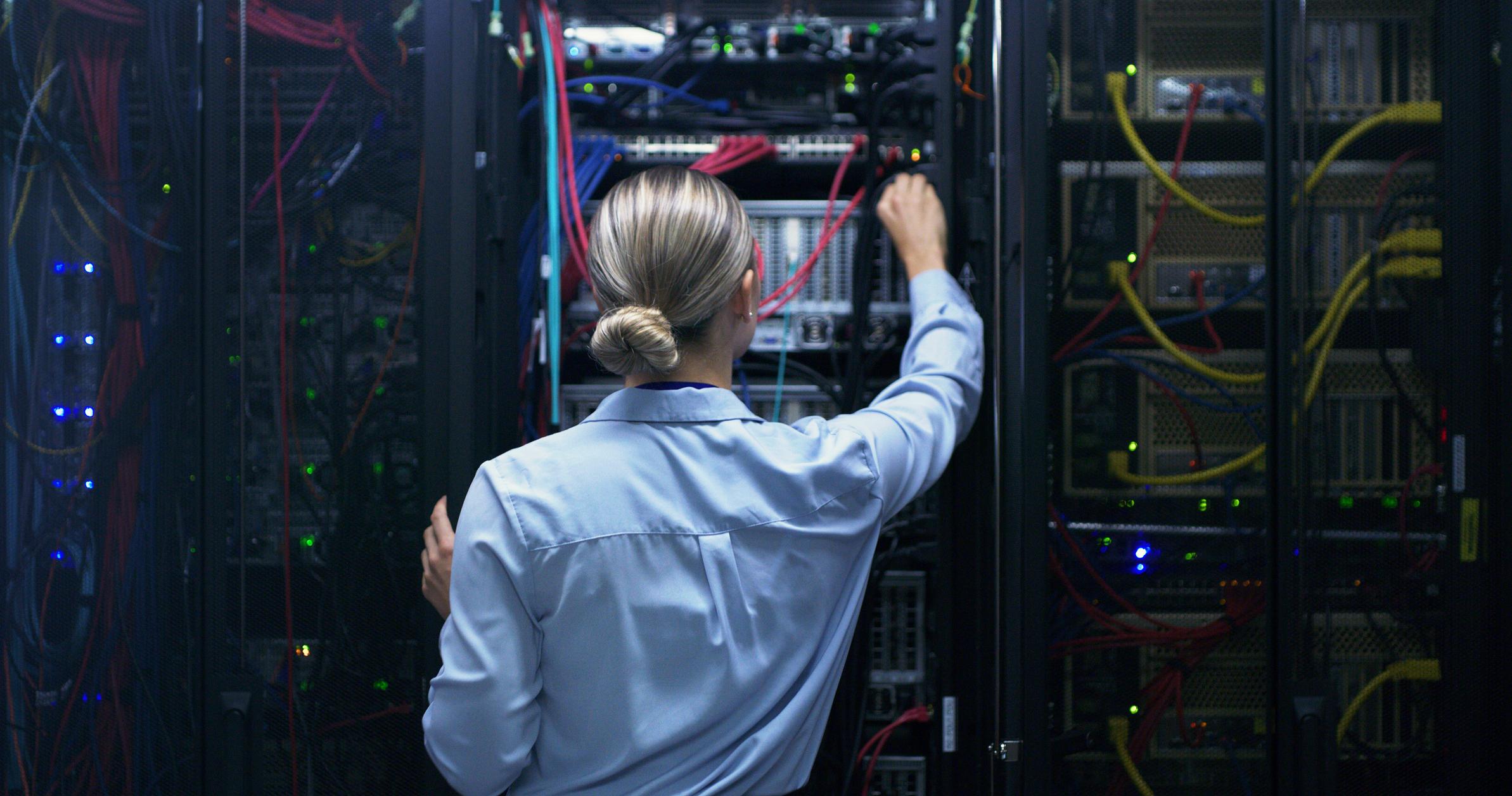 Technician testing cables in a data center